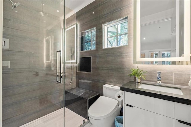 bathroom with toilet, an enclosed shower, tile walls, vanity, and backsplash