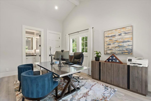 office space with beamed ceiling, high vaulted ceiling, and light hardwood / wood-style floors