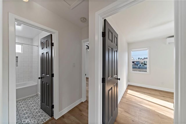 corridor featuring an AC wall unit and light hardwood / wood-style flooring