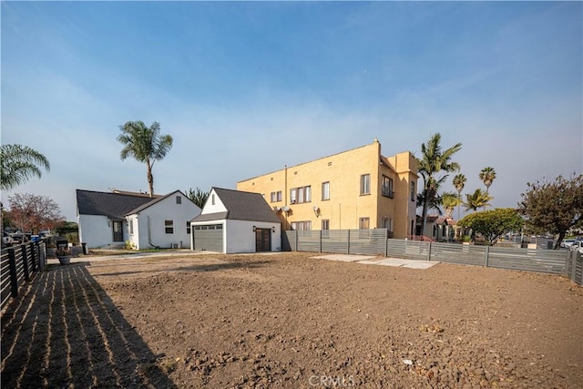 rear view of property featuring an outdoor structure and a garage