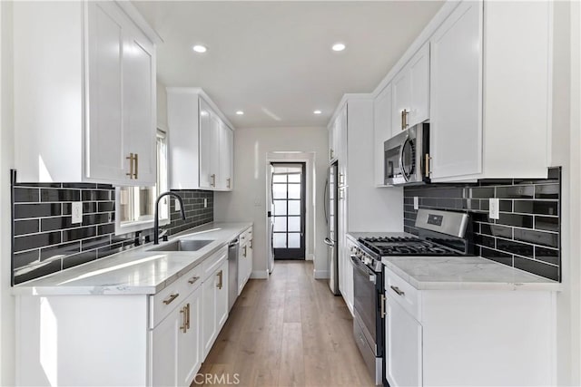 kitchen featuring white cabinetry, light stone countertops, and appliances with stainless steel finishes