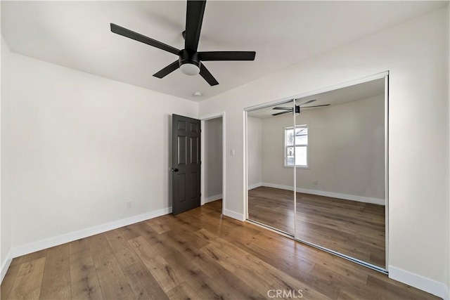 unfurnished bedroom with ceiling fan, wood-type flooring, and a closet