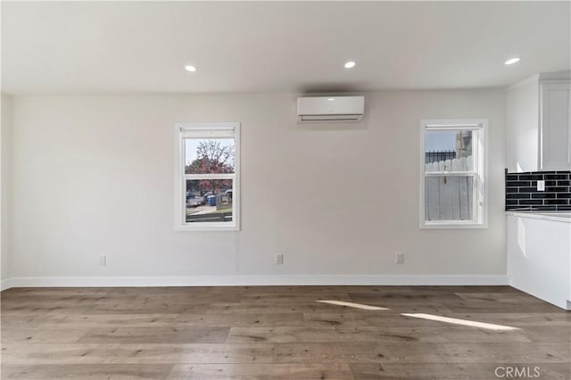 interior space with hardwood / wood-style floors and a wall mounted AC