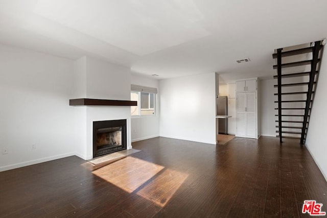 unfurnished living room with dark hardwood / wood-style floors