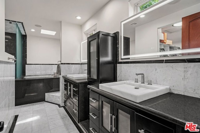 bathroom featuring vanity, tile walls, and a skylight