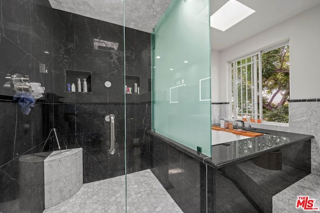 bathroom with tiled shower and tile walls