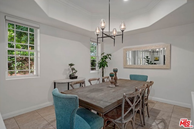 dining space with light tile patterned floors, a raised ceiling, crown molding, and a healthy amount of sunlight