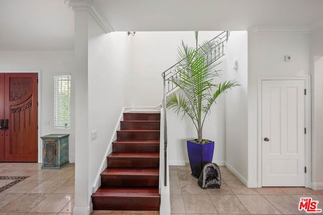 stairs with tile patterned floors and ornamental molding