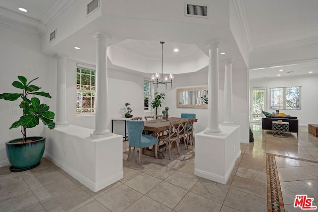 tiled dining space with a raised ceiling, crown molding, and a notable chandelier