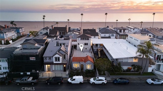 aerial view at dusk featuring a water view