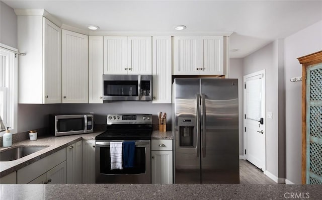 kitchen featuring dark hardwood / wood-style floors, white cabinetry, sink, and appliances with stainless steel finishes