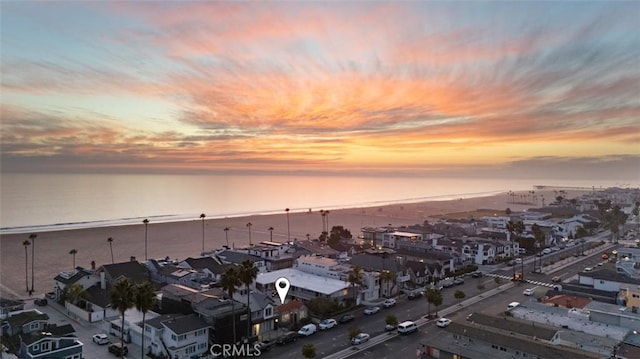 aerial view at dusk featuring a water view