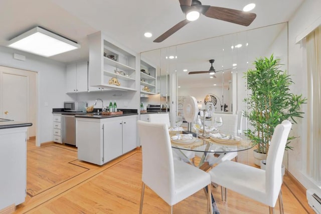 kitchen with ceiling fan, dishwasher, white cabinetry, baseboard heating, and light hardwood / wood-style floors