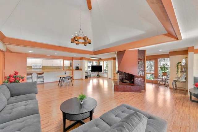 living room featuring a multi sided fireplace, a chandelier, and light wood-type flooring