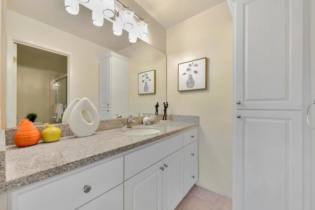 bathroom with tile patterned flooring, vanity, and walk in shower