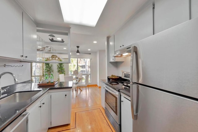 kitchen featuring sink, white cabinets, ceiling fan, stainless steel appliances, and light wood-type flooring