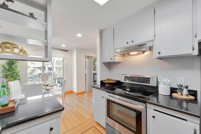 kitchen with light wood-type flooring, white cabinets, and stainless steel electric range oven