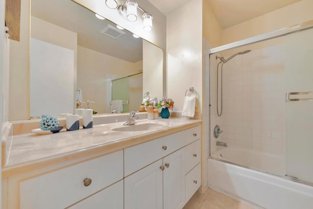 bathroom featuring vanity, bath / shower combo with glass door, and tile patterned floors