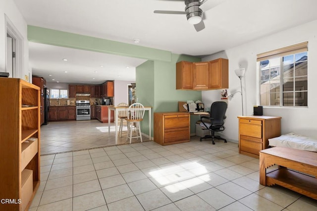 office with light tile patterned floors, ceiling fan, and a healthy amount of sunlight