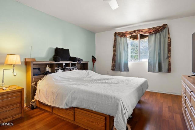 bedroom with dark hardwood / wood-style flooring