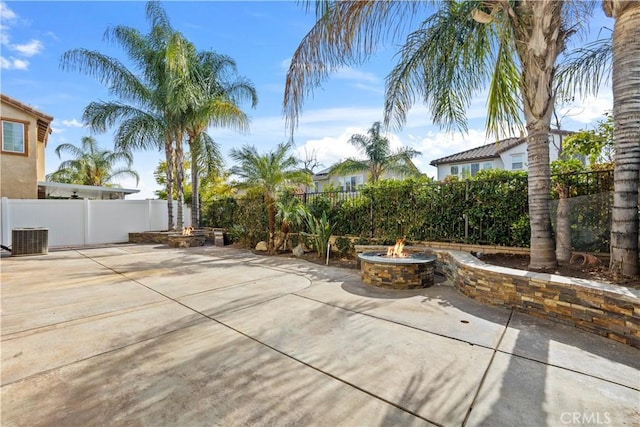 view of patio featuring central AC unit and a fire pit