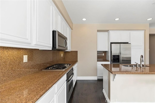 kitchen featuring dark stone countertops, sink, white cabinets, and appliances with stainless steel finishes