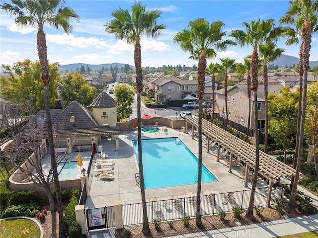 view of pool with a hot tub, a patio, and a mountain view