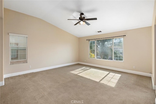 spare room with ceiling fan, vaulted ceiling, and carpet