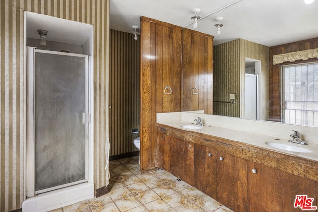 bathroom featuring vanity, toilet, and a shower with shower door