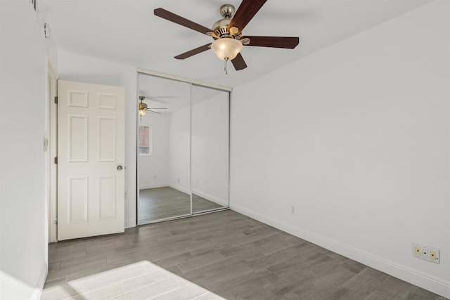 unfurnished bedroom featuring ceiling fan, a closet, and light hardwood / wood-style floors