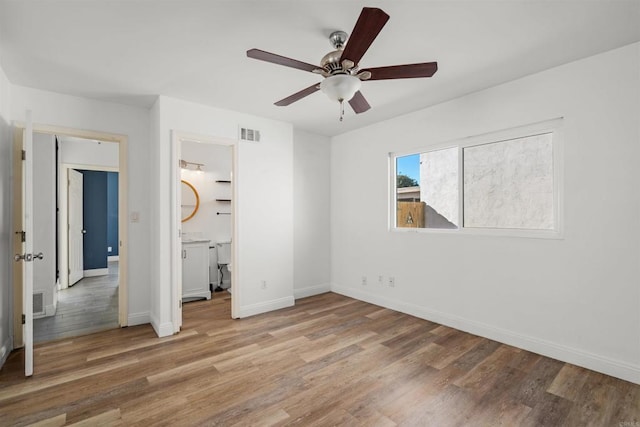 unfurnished bedroom with connected bathroom, light hardwood / wood-style flooring, and ceiling fan