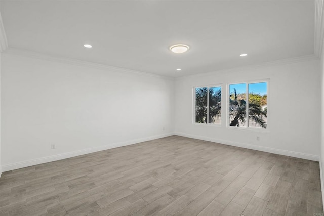 empty room featuring wood finished floors, baseboards, and ornamental molding