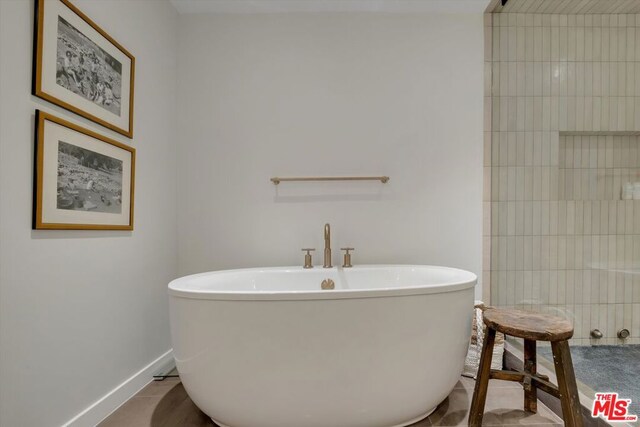 bathroom with tile patterned flooring and a bathtub