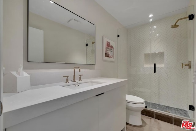 bathroom with toilet, tile patterned flooring, a shower with shower door, and vanity