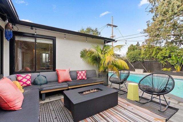 deck featuring a fenced in pool and an outdoor living space with a fire pit