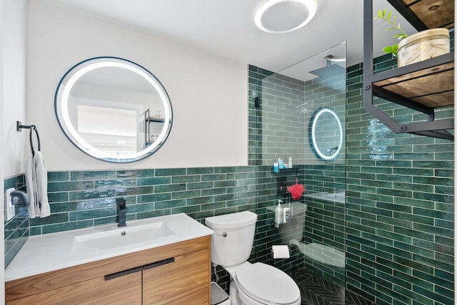 bathroom featuring tiled shower, vanity, toilet, and tile walls