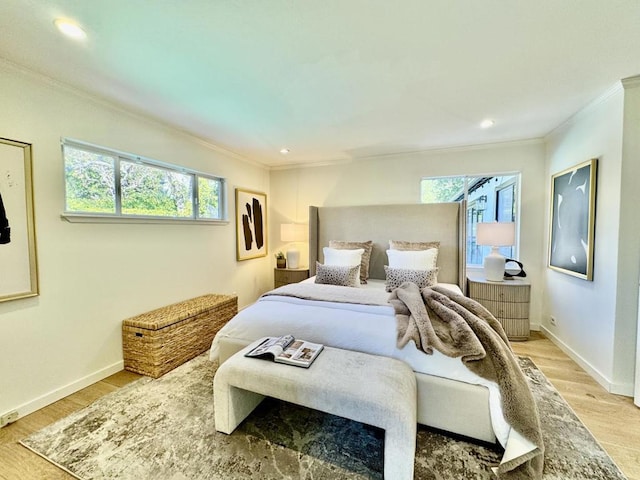 bedroom with crown molding and light hardwood / wood-style floors