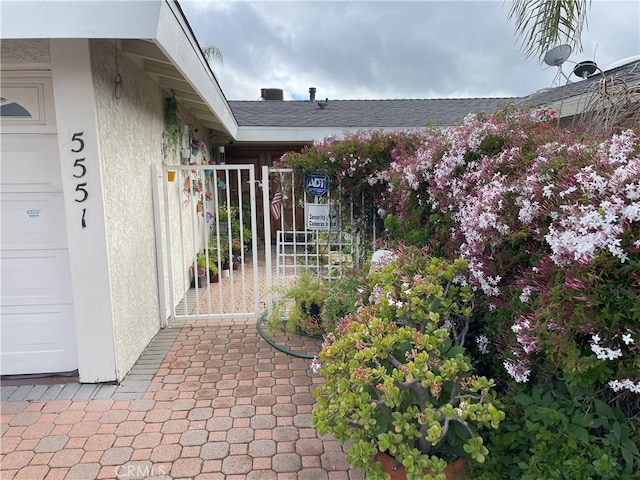 exterior space with stucco siding and a gate