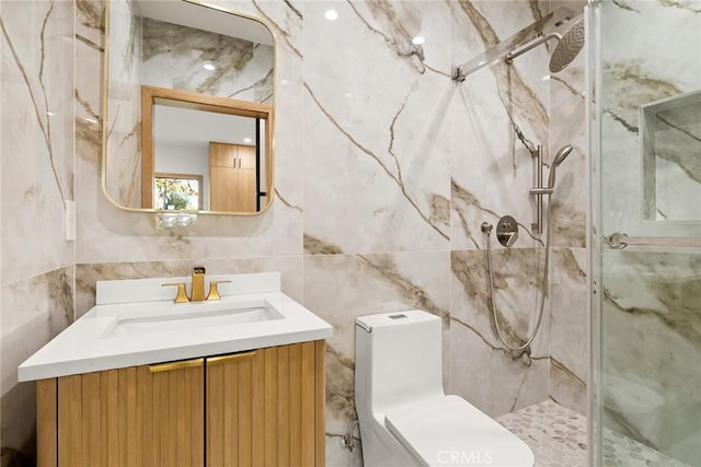 bathroom featuring vanity, toilet, a shower with shower door, and tile walls