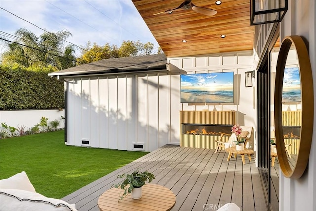 wooden deck with ceiling fan, visible vents, and a lawn