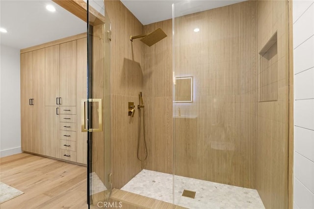 bathroom featuring a shower with shower door and wood-type flooring