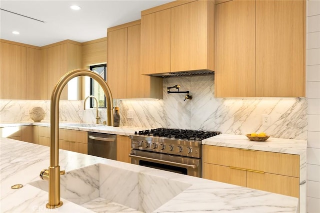 kitchen featuring stainless steel appliances, light brown cabinetry, backsplash, and light stone counters