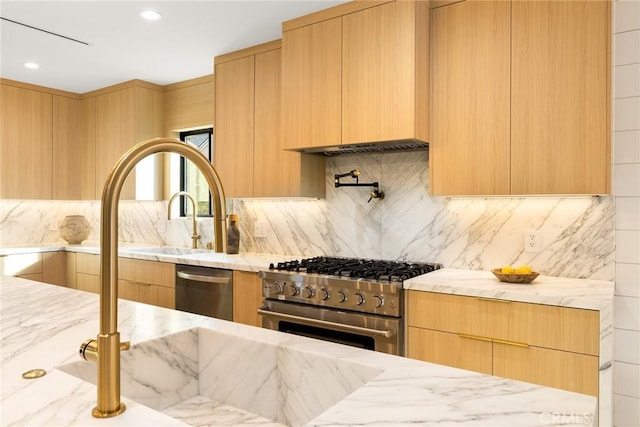 kitchen featuring stainless steel appliances, light stone counters, and modern cabinets