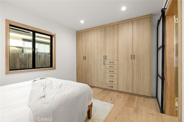 bedroom with light wood-style floors and recessed lighting