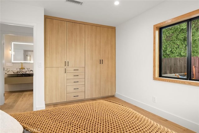 unfurnished bedroom featuring light hardwood / wood-style flooring and a closet