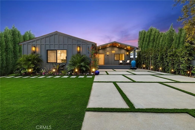 view of front of home featuring board and batten siding and a lawn