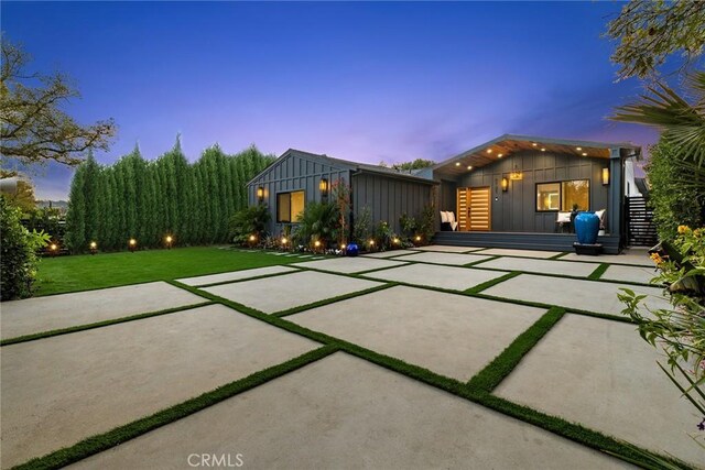 view of front of home with a patio area and a lawn