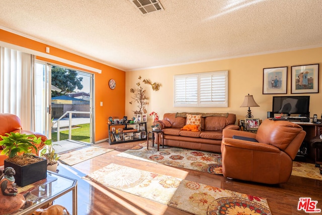 living room featuring a textured ceiling, hardwood / wood-style flooring, and crown molding