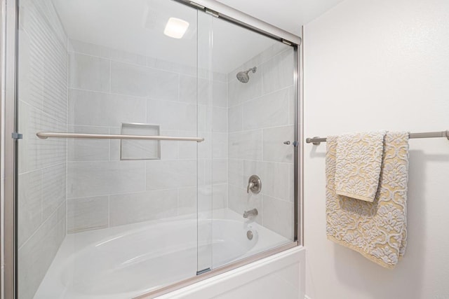 bathroom with bath / shower combo with glass door