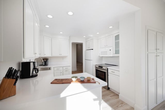 kitchen featuring white cabinetry, sink, kitchen peninsula, light hardwood / wood-style floors, and white appliances